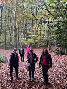 A group of people stood looking at camera in woods.  A benefit of coaching outdoors is walking side by side.